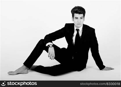 Portrait of a young businessman wearing a suit, barefoot, isolated on white background