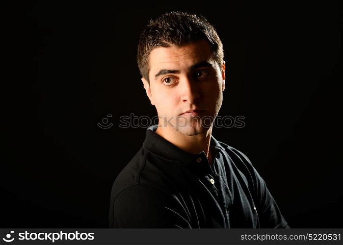Portrait of a young casual man on black background