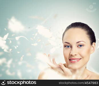 Portrait of a young charming girl. Portrait of a young charming girl on a background of soaring light feathers