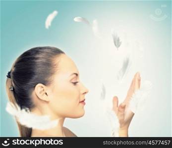 Portrait of a young charming girl. Portrait of a young charming girl on a background of soaring light feathers