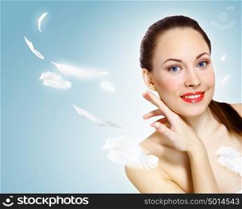 Portrait of a young charming girl. Portrait of a young charming girl on a background of soaring light feathers