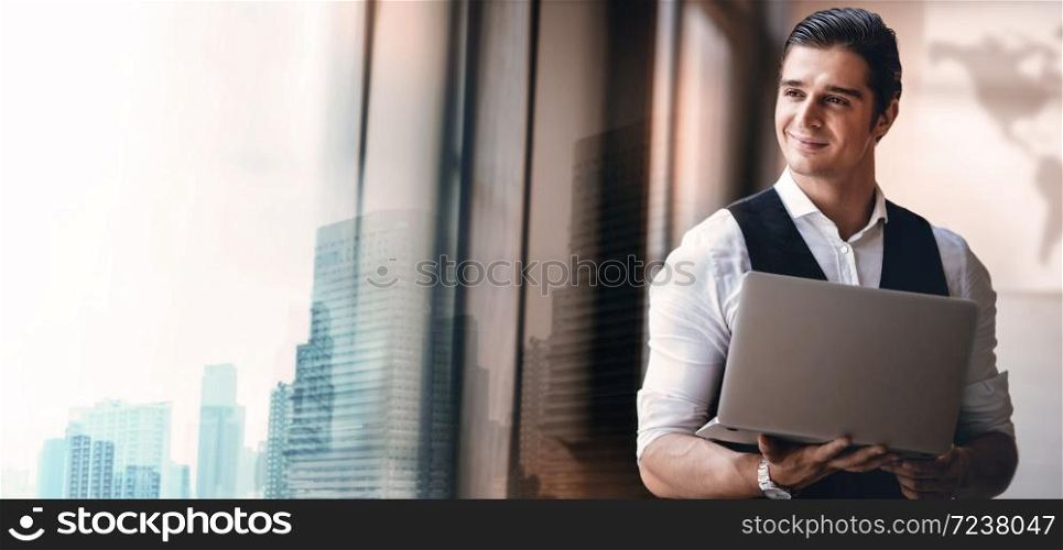 Portrait of a Young Confident CEO or Leader Working on Computer Laptop in the Modern Workplace. Smiling Businessman Standing by the Window and Looking outside