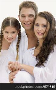 Portrait of a young couple and their daughter smiling