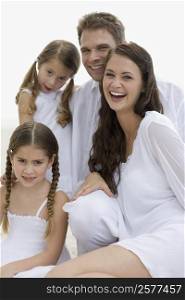 Portrait of a young couple and their two daughters smiling