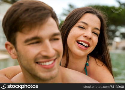 Portrait of a young couple embraced inside the pool