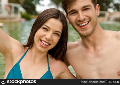 Portrait of a young couple embraced inside the pool