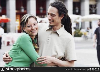 Portrait of a young couple embracing each other and smiling