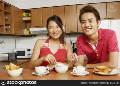Portrait of a young couple having breakfast at a kitchen counter