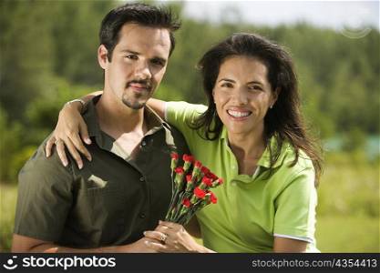 Portrait of a young couple holding a bunch of roses