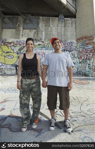 Portrait of a young couple holding each other&acute;s hand and smiling