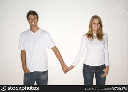 Portrait of a young couple holding each other&acute;s hands and smiling