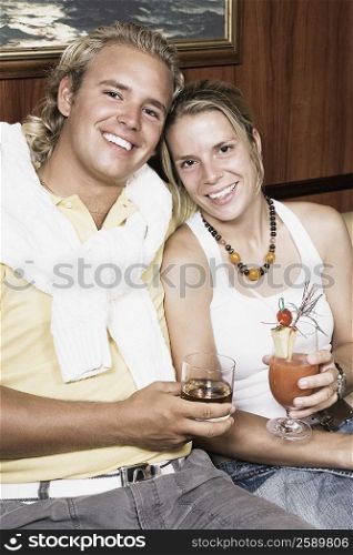 Portrait of a young couple holding glasses of cocktail