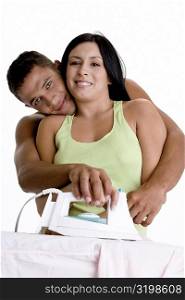 Portrait of a young couple ironing on an ironing board