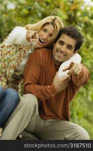 Portrait of a young couple pointing forward