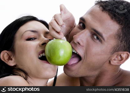 Portrait of a young couple sharing a green apple
