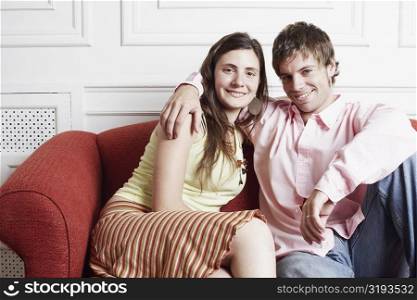 Portrait of a young couple sitting on a couch and smiling