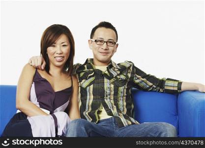 Portrait of a young couple sitting on a couch smiling
