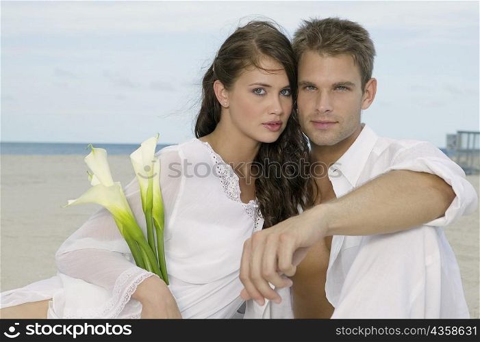 Portrait of a young couple sitting on the beach