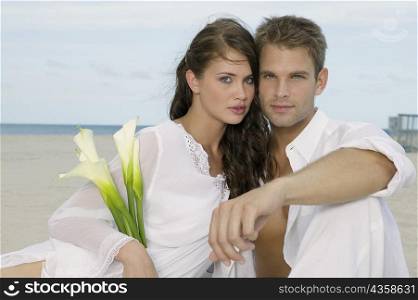 Portrait of a young couple sitting on the beach