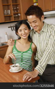 Portrait of a young couple smiling at a kitchen counter