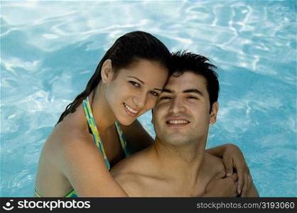 Portrait of a young couple smiling in a swimming pool