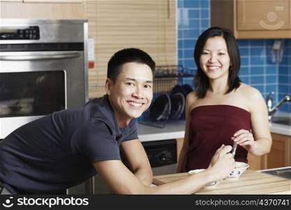 Portrait of a young couple smiling in the kitchen