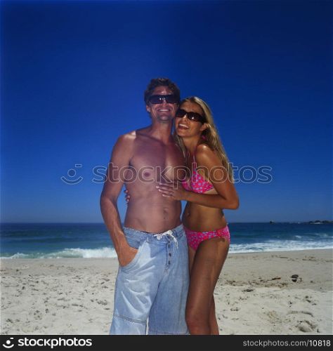 Portrait of a young couple standing on the beach