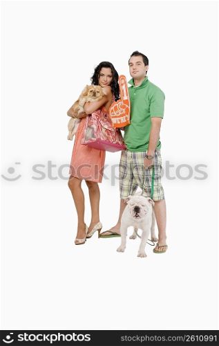 Portrait of a young couple standing with dogs