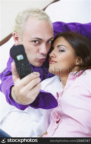 Portrait of a young couple taking a photograph of themselves with a mobile phone