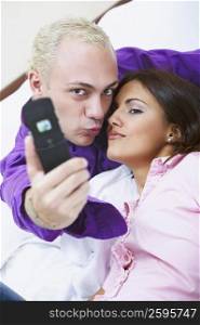 Portrait of a young couple taking a photograph of themselves with a mobile phone