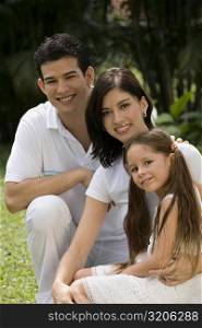 Portrait of a young couple with their daughter in a park