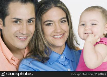 Portrait of a young couple with their daughter smiling