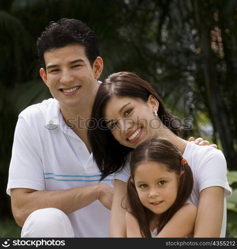 Portrait of a young couple with their daughter smiling