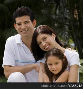 Portrait of a young couple with their daughter smiling