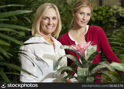 Portrait of a young daughter with senior mother in botanical garden