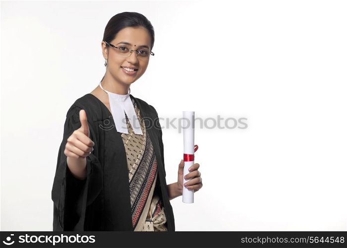Portrait of a young female lawyer showing thumbs up sign isolated over white background