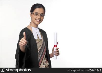 Portrait of a young female lawyer showing thumbs up sign isolated over white background