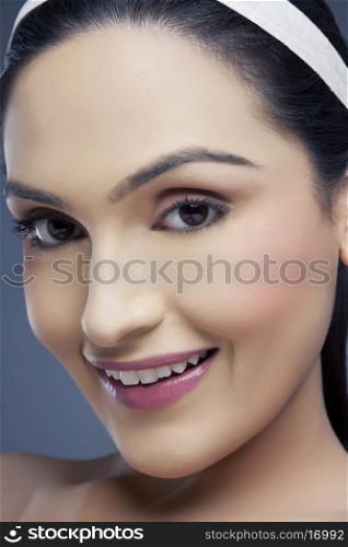 Portrait of a young female smiling over colored background