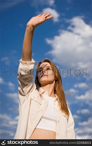 Portrait of a young girl against a clear sky and small clouds.. Portrait of a young girl against a background of blue sky and clouds 3695.