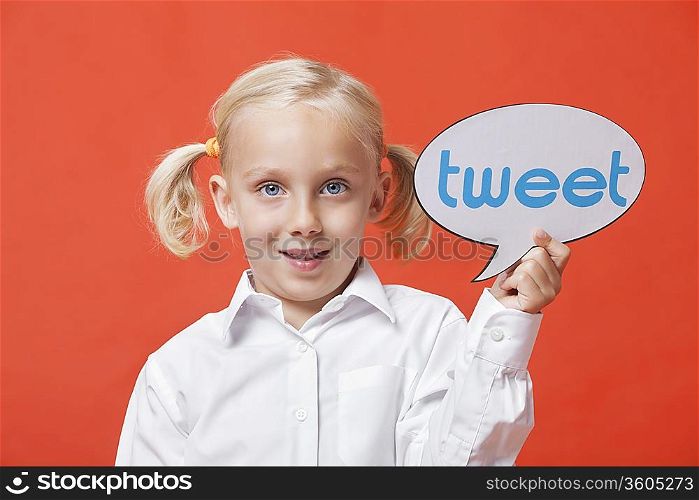 Portrait of a young girl holding tweet bubble against orange background