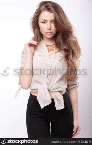 Portrait of a young girl in a beige shirt and fashionable pants.