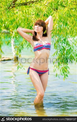 portrait of a young girl in a striped bathing suit in the water