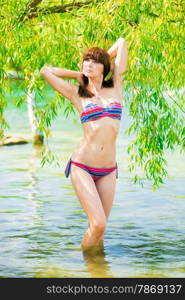 portrait of a young girl in a striped bathing suit in the water