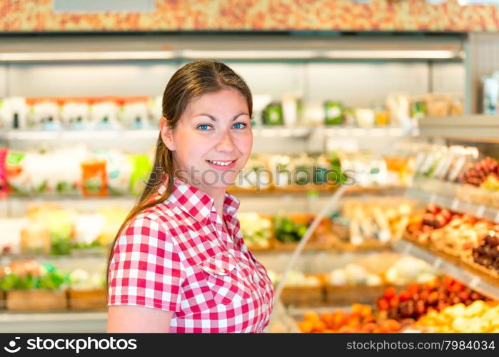 Portrait of a young girl in a supermarket vegetable department