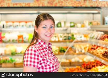 Portrait of a young girl in a supermarket vegetable department