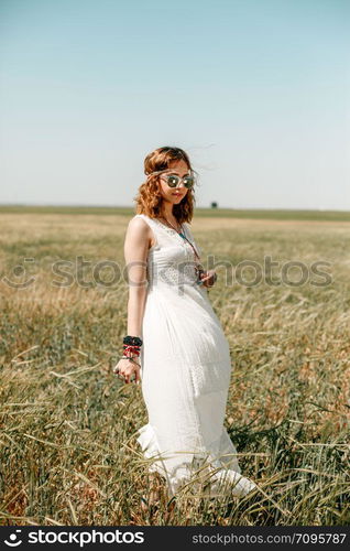 portrait of a young girl in a white translucent dress in boho or hippie style