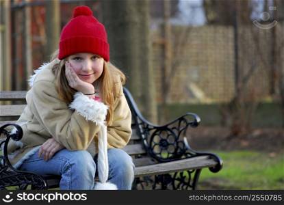 Portrait of a young girl sitting on a bench