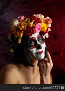 Portrait of a young girl with makeup in the image of Katrina for the holiday of the Day of the Dead. Sugar skull makeup. spider web background with black spiders