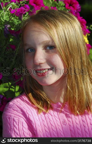 Portrait of a young girl with pink petunia flowers