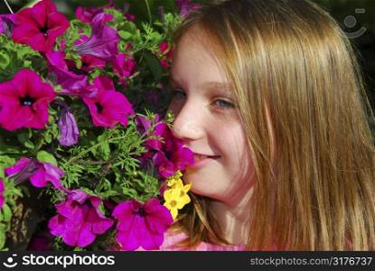 Portrait of a young girl with pink petunias